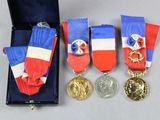 trois médailles et une médaille se trouvent dans un écrin posé sur une table