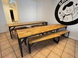 tables and benches in a room with a mural on the wall