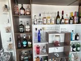 de nombreuses bouteilles et verres sur les étagères de la cuisine