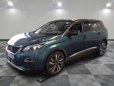 la voiture bleue est garée sur le sol en damier d'un garage