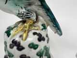 a figurine of a bird sitting on top of a vase