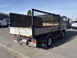 a truck with a cage on the back parked in a parking lot