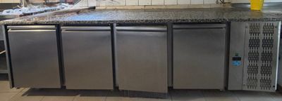 une cuisine équipée d'appareils électroménagers en inox et d'un plan de travail en granit