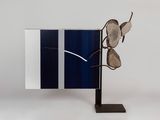sculpture of a pair of glasses on a stand with a mirror in the background