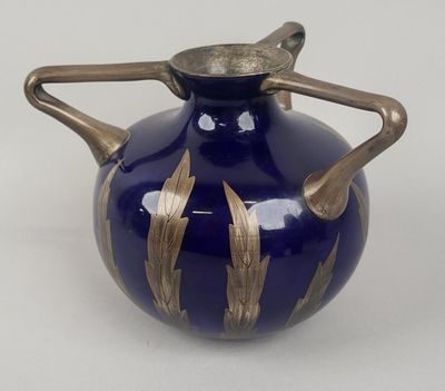un vase bleu orné de motifs dorés sur fond blanc
