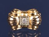 bague en or jaune ornée d'un diamant au centre et d'un nœud autour de l'anneau