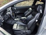the interior of a silver car with black leather seats and a steering wheel