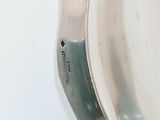 a silver plate with a silver handle on a white table