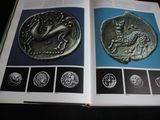 an open book with a picture of a coin and a picture of a horse
