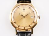 une montre en or avec un bracelet noir sur un fond blanc