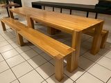 une table en bois avec deux bancs au milieu de la pièce