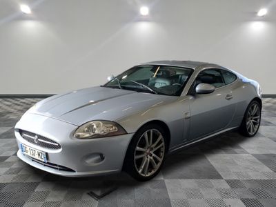 une photo d'une voiture de sport argentée garée dans un garage