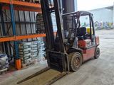 a forklift in a warehouse with pallets on the floor