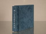 blue book sitting on top of a table next to a glass table