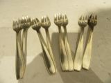 quatre fourchettes et cuillères en argent posées sur une table