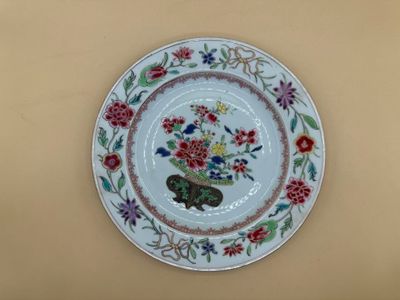 une assiette décorée d'une composition florale, accrochée au mur