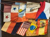 Plusieurs drapeaux différents sont disposés sur une table dans une pièce