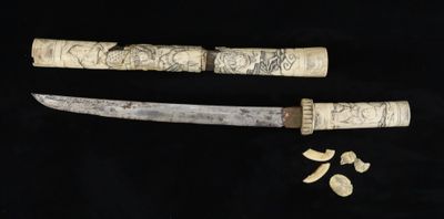 two knives with carvings on them sitting next to each other
