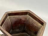 a brown vase with a handle on a white surface