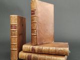 several old books are stacked on top of each other on a table