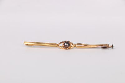 an image of a gold tie bar with a knot on it