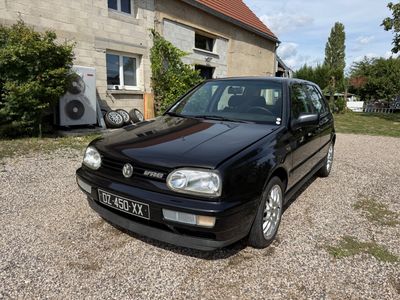 a small black car parked in front of a house
