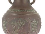 a brown vase with a green design on it