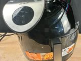 a black and silver air fryer on a wooden table