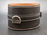 a black leather bracelet with a silver buckle on it