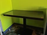 a black table and a black refrigerator in the corner of a room