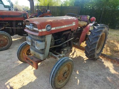 a red tractor that is parked in the dirt