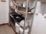 des étagères sur lesquelles sont posées des casseroles et des poêles dans une petite cuisine