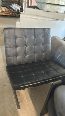 un fauteuil en cuir noir et une chaise noire dans une pièce