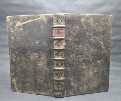 an old book that is open on a gray surface