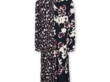 une robe à fleurs noire et blanche suspendue à un cintre sur un mur blanc