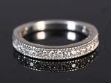 a close up of a diamond ring on a black surface