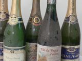 six bottles of wine are lined up in a row on a white surface