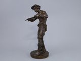 a bronze statue of a man holding a gun on a white background
