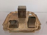 a silver tray with a candle and a box on it