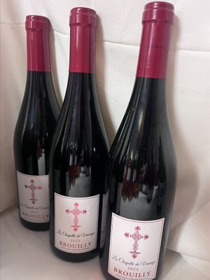 trois bouteilles de vin rouge sont alignées sur une étagère