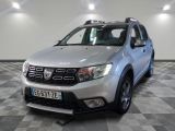 une photo d'une Dacia argentée garée sur un sol à damier