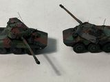 two toy tanks sitting next to each other on a table