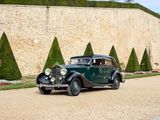 a vintage car that is parked in front of a stone wall