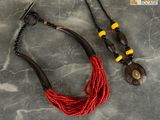 a close up of a necklace and a pair of earrings on a table