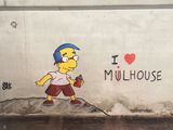 peinture représentant un homme avec un skateboard sur un mur où l'on peut lire « J'adore Mulhouse »