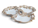 two white and gold plates with gold designs on them on a white surface