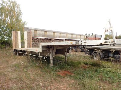 un camion garé dans l'herbe près d'un bâtiment