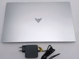 a silver laptop with a charger and a charger plugged into it