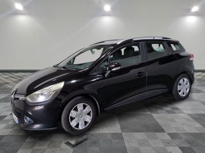 une voiture noire est garée dans une pièce au sol en damier