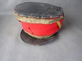 un chapeau rouge orné d'un ruban doré sur le dessus